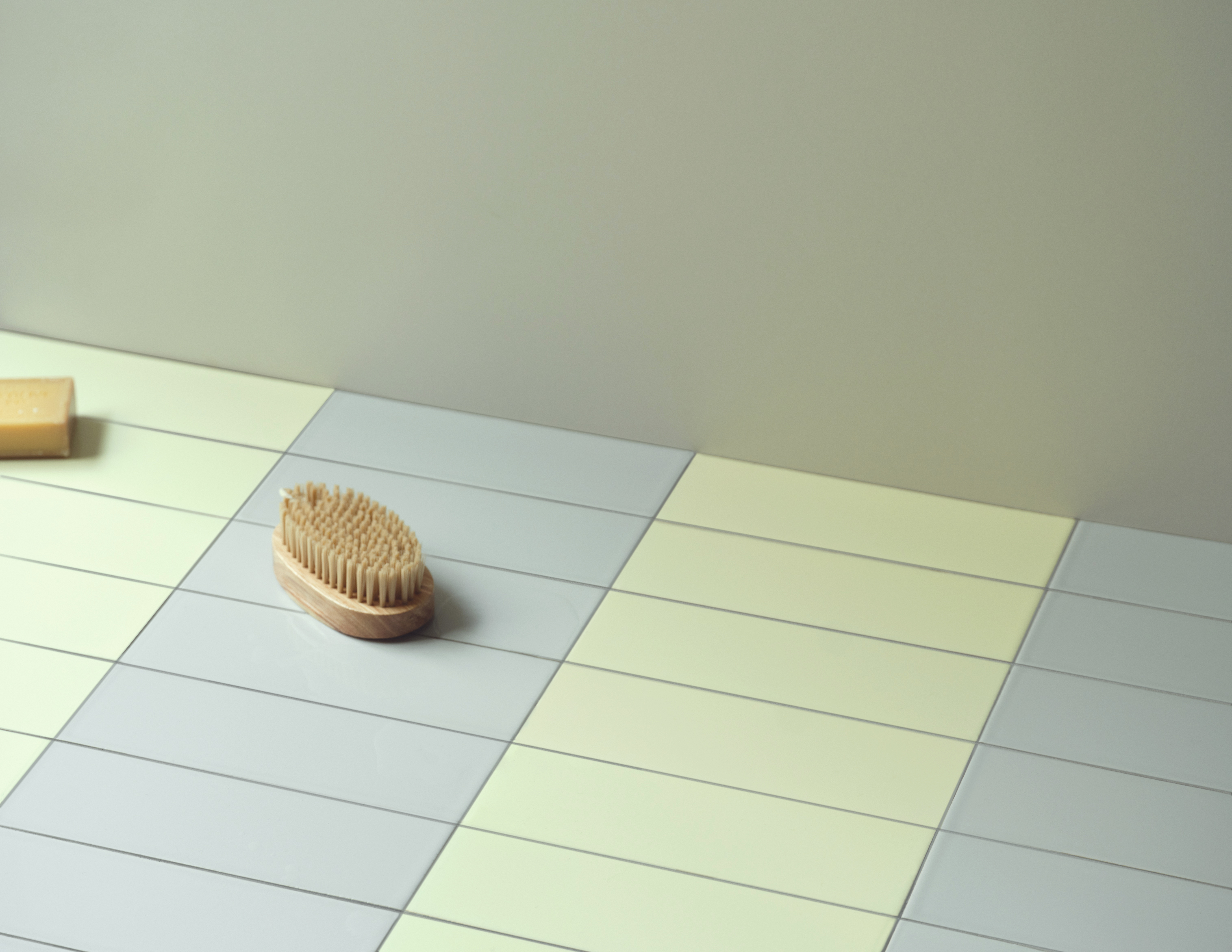 A tiled floor with a light gray and pale yellow stripe pattern.